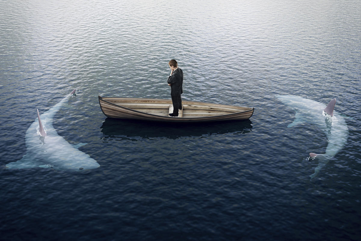 man in boat surrounded by sharks risk fear decision attack threat by peshkova getty 100786972 large